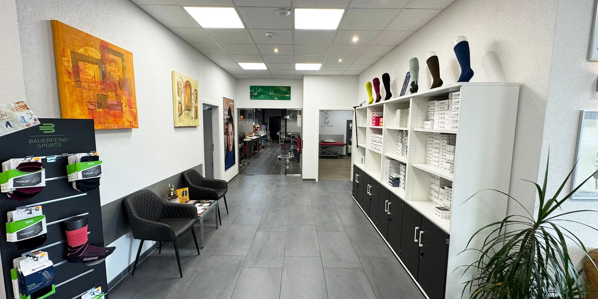 Heller Empfangs- und Wartebereich mit Sitzgelegenheiten und Produktregalen.